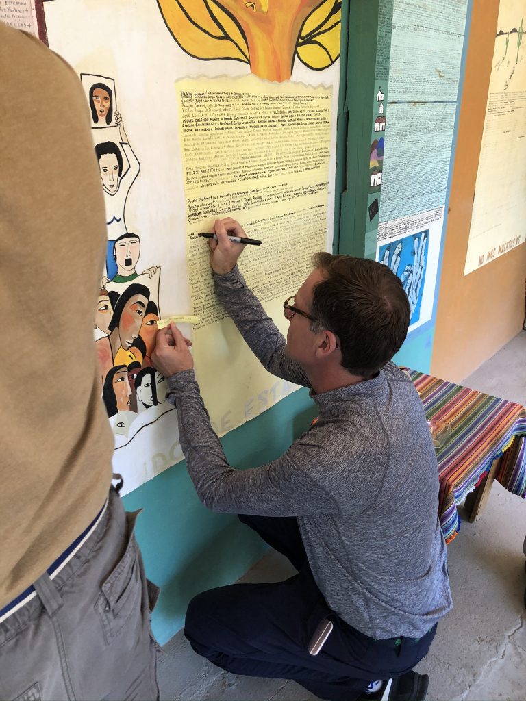 Participant writes a name on the mural